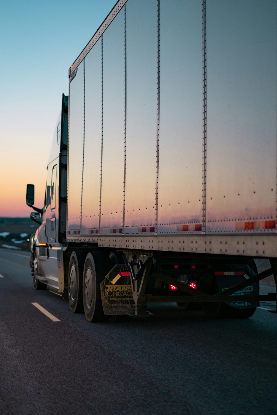 Dry van trailer on highway near sunset